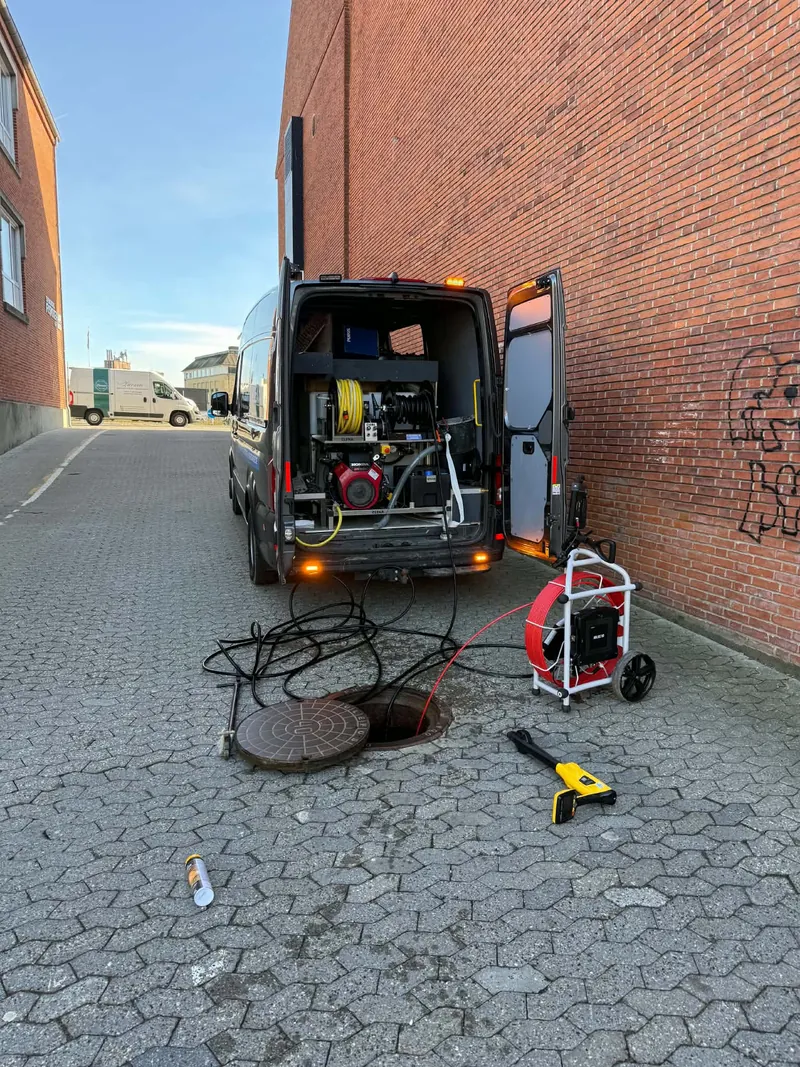 Øens Anlæg & Rørtekniks spuleudstyr og inspektionskamera ved en åben kloakbrønd